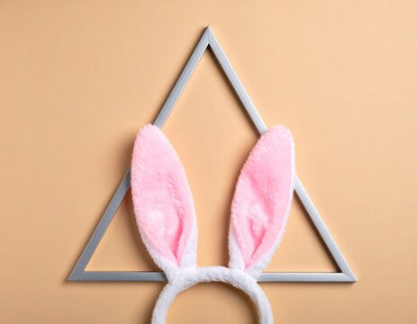 Easter bunny ears inside a silver triangle on a solid peach background