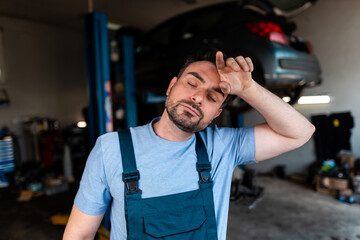 Mechanic feeling tired after a long day of work in the garage