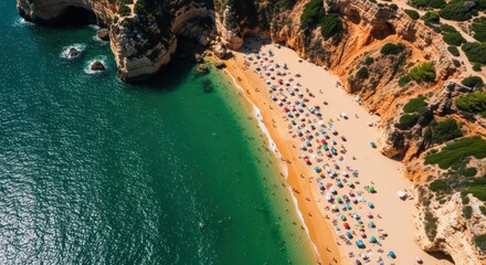 Aerial view of a crowded summer beach with colorful umbrellas. Turquoise ocean water and golden sand coastline. People enjoying a sunny holiday at a popular tourist destination