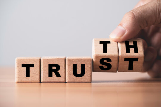 Wooden blocks showing the words TRUST and TRUTH with a hand arranging letters symbolizing honesty reliability and transparency in business concept for integrity and authentic communication