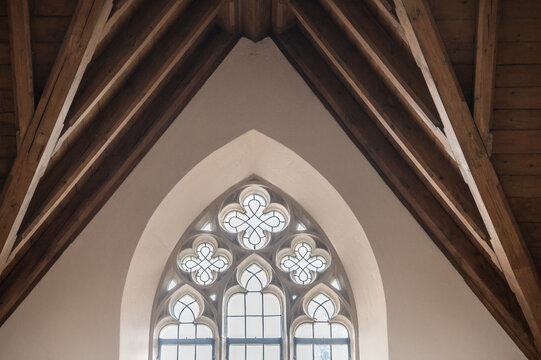 Gotisches Kirchenfenster Ma&szlig;werk Vierpass mit Bleiverglasung und Spitzbogen und Eichenbalkendecke in der Stiftskirche in Dettingen an der Erms 