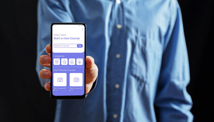 Person holding smartphone displaying e-learning application interface