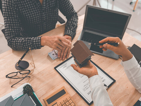 Real estate mortgage loan approval, home purchase document insurance, male agent points to paper to sign contract with tenant, home mortgage agreement