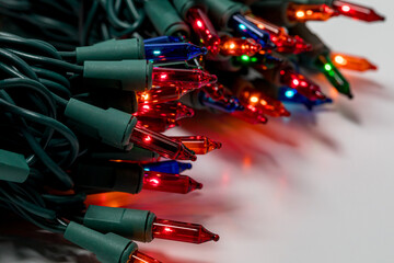 New Christmas string lights turned on and glowing. Holiday decoration safety and lighting concept.
