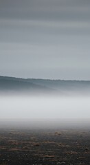 A thick layer of atmospheric haze obscures the landscape, creating a desolate, empty, and muted background suitable for overlays or copy space ,blank ,fog ,white