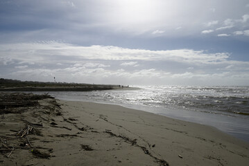 Mediterranean Beach at Tore del lago Puccini. Autumn sky with little sun. Reflections in water.