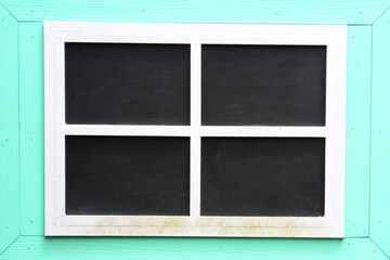 Four black chalkboard panels set within a light blue or mint-colored wooden frame, ideal for a mockup or presentation background.
