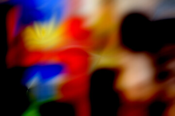 An abstract bokeh background with a blend of red, yellow, and blue colors, creating a cheerful, blurred effect.