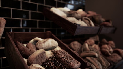 Wooden baskets display an array of artisanal breads, each with unique textures and colors. The warm tones of the bakery create a welcoming atmosphere for visitors.