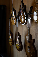 verschiedene E-Gitarren mit Preisschildern aufgeh&auml;ngt in einem Musikladen nat&uuml;rliches Licht 