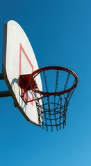Close-up view of a basketball backboard and hoop against a bright blue sky, perfect for sports design and graphic backgrounds ,background ,active ,success