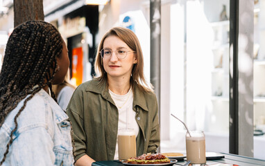 Diverse women enjoying conversation and coffee at cafe
