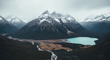 Majestic snow capped mountain range. Turquoise glacial lake in a remote valley. Winding river flowing through a forest. Epic cinematic landscape for travel and adventure concepts