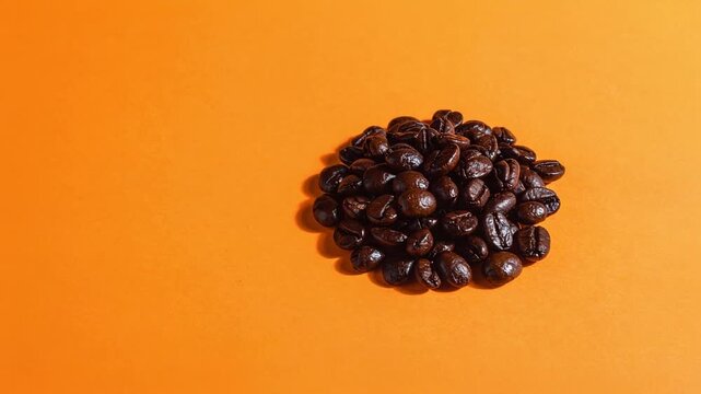 光沢のある深煎りコーヒー豆が焙煎の深みを示す温かみある橙色の背景構成