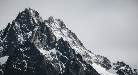 Obraz premium Majestic mountain peak with snow covered slopes. Dramatic alpine landscape with a minimalist aesthetic. Symbol of challenge and achievement in business. Natural scenery for corporate branding