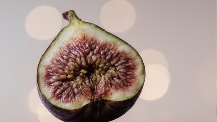 Close-up of a halved fig with a blurred background, showcasing its vibrant interior and seeds.