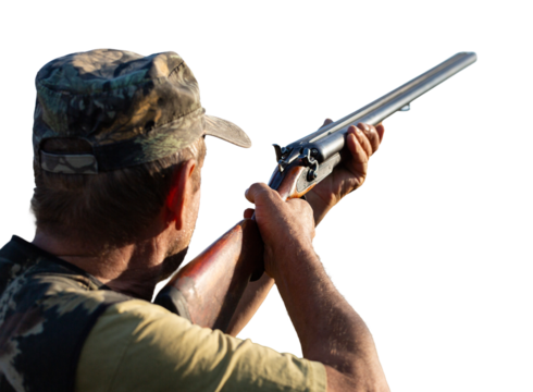 An adult hunter hunts in the autumn countryside. He fires a shotgun.