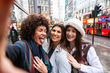 Women friends taking selfie on city street