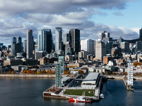 Aerial view of Montreal Old Port, downtown, historic buildings and waterfront under blue sky. g.