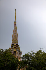 An old beautiful Buddhist temple on a background of trees. Ancient Asian architecture. Temple in Thailand.	

