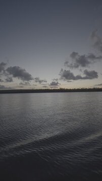POR DO SOL NO JACAR&Eacute;, A VISTA VENDO DE UM BARCO PELO RIO (Sunset at Jacar&eacute;, the view seen from a boat on the river.)