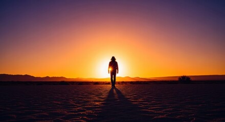 A solitary person walking towards a vibrant sunrise. Conceptual journey of self discovery and exploration. Metaphor for new beginnings and future vision in business and life