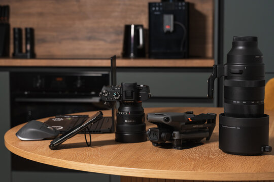 TALLINN, ESTONIA - NOVEMBER 9, 2025: A setup of modern digital photography and videography equipment, including a DJI Mavic 3 Classic drone, a Sony Alpha 7 IV camera, and a Sigma 150-600mm Sport lens.