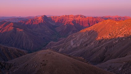 Fototapeta premium Majestic mountain range bathed in warm, vibrant sunset glow, evoking peace and natural wonder