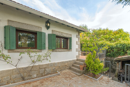 A south-facing access walkway boasts polished granite paving and walls covered with Virginia creeper that changes color with the seasons