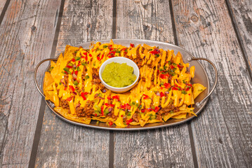 nachos with shredded beef, smoky BBQ sauce, and crispy onion rings