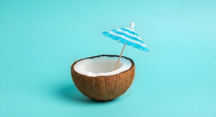 Refreshing tropical coconut drink with blue and white umbrella and straw on a vibrant teal background