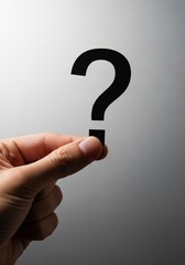 Hand holding a paper question mark cutout