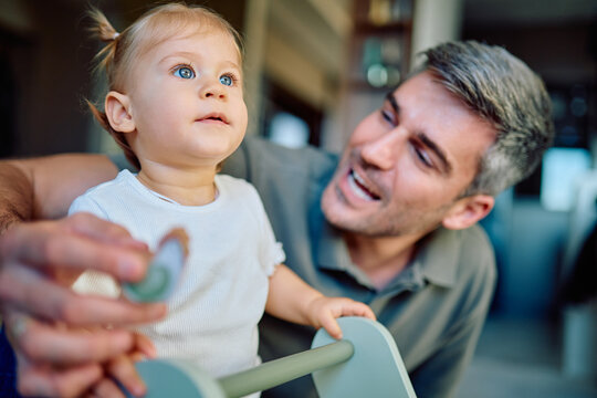 Adorable baby girl with blue eyes engaging with her smiling father enjoying family time and childhood development - Powered by Adobe