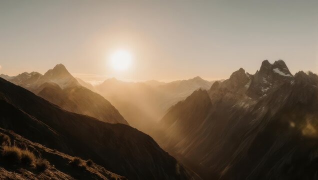 Golden sunrise casting warm light over a majestic mountain valley.