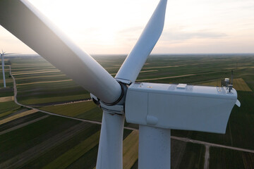 Aerial view of wind turbine on an agricultural filed at sunset. Close up of blades © scharfsinn86