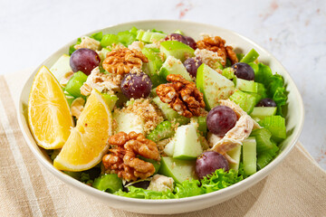 Fresh Waldorf salad, celery stalk with chicken, apple and walnuts, grapes, herbs, homemade, without people,