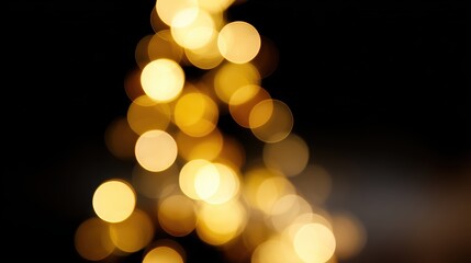 Obraz premium Bokeh effect of yellow Christmas tree lights on black background, festive holiday glow