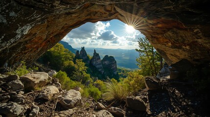 View from inside a dark cave looking out at a vibrant green forest and dramatic rock formations under a cloudy sky