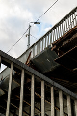 Fototapeta premium Close-up view of an old metal bridge with corroded and rusted structures, weathered steel beams showing decay and danger for pedestrians.