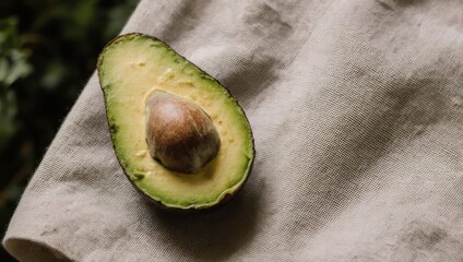 Natural Organic Avocado Half with Seed on a Textured Napkin.