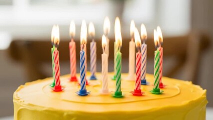 Close-up view of a delightful yellow frosted birthday cake adorned with vibrant colorful candles