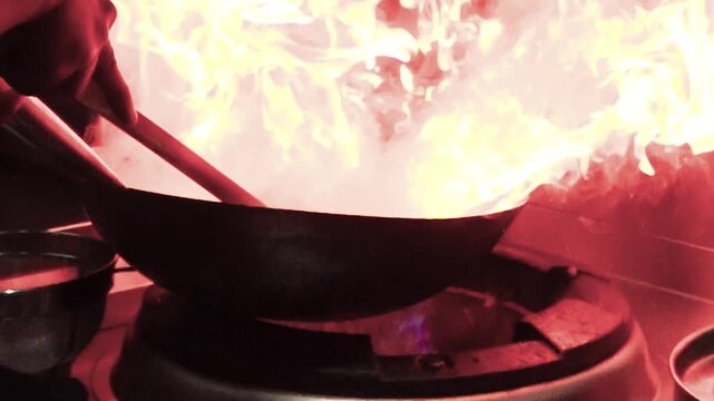 slow motion flames rising from a cooing pot- dramatic fire explosion in kichen scene