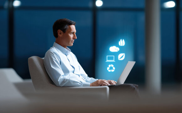 Focused businessman working on laptop with glowing ESG technology icons. concept for sustainability, green energy, recycling, and future corporate responsibility