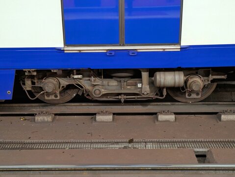 Vista de cerca de un bogie ferroviario de un vag&oacute;n de metro en las v&iacute;as de una estaci&oacute;n 