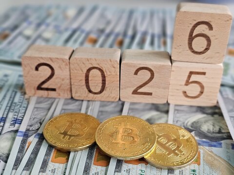 Cryptocurrency market projections with wooden blocks showing 2026 and gold bitcoins on cash