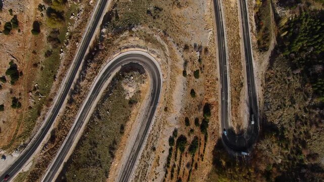 A winding asphalt road with sharp turns through mountainous terrain. Travel, adventure, and challenging terrain.