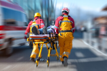 Emergency medical team transporting injured person to ambulance in city street