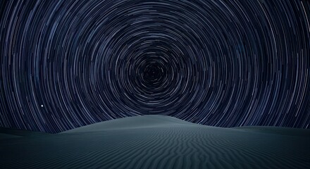 Celestial motion creates concentric white streaks above dark desert dunes under a night sky