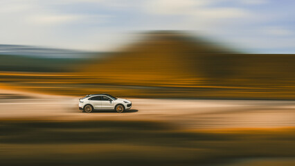 Car driving at high speed. Side view of a fast-moving white car