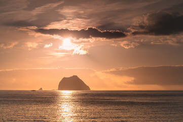 The sun rises over the sea, casting a beautiful golden light on the Keelung Islet and Little Keelung Islet near the Waimushan coastline in Keelung, Taiwan.